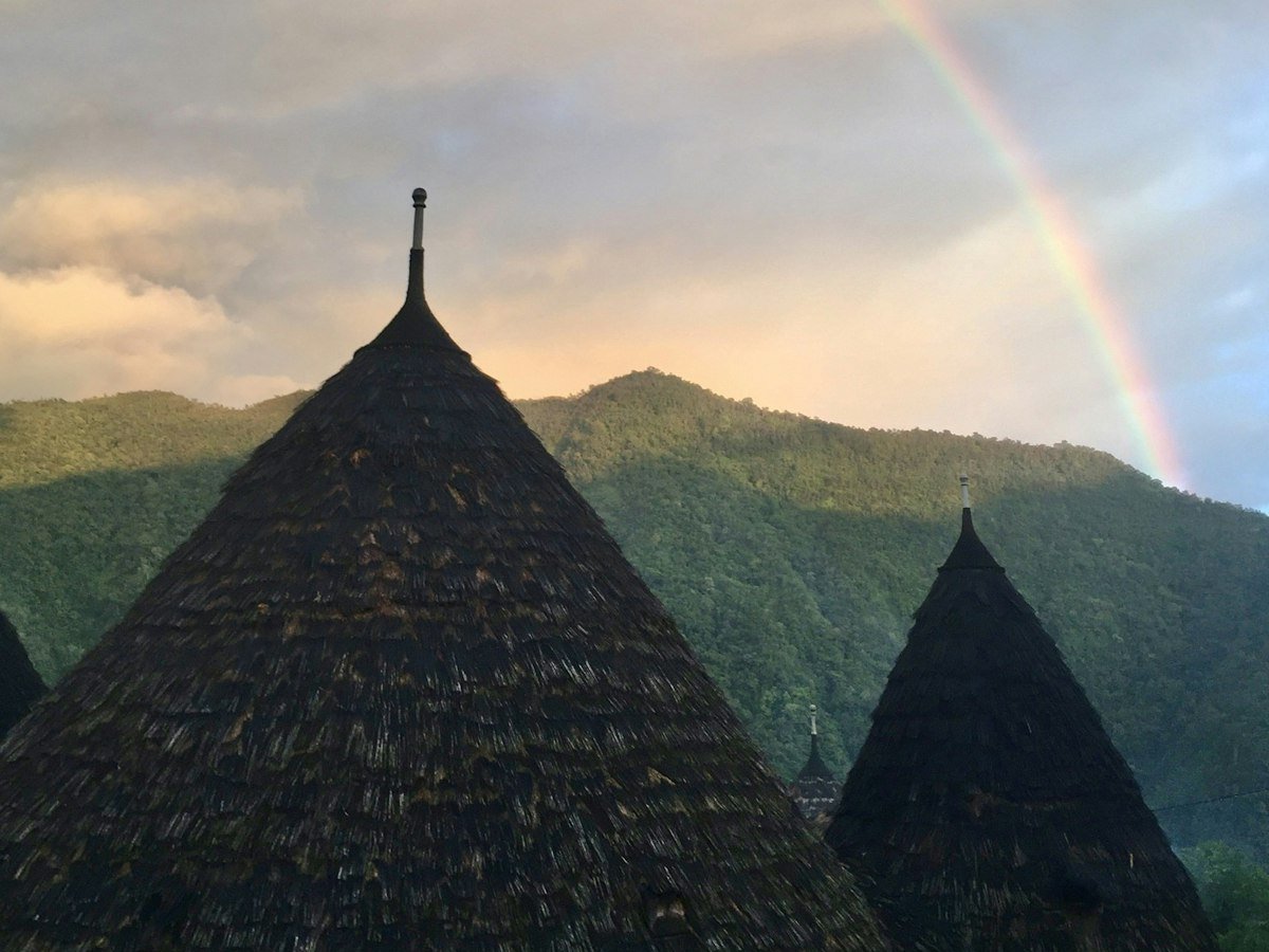 Wae Rebo huizen met regenboog boven de Manggarai-bergen na de regen